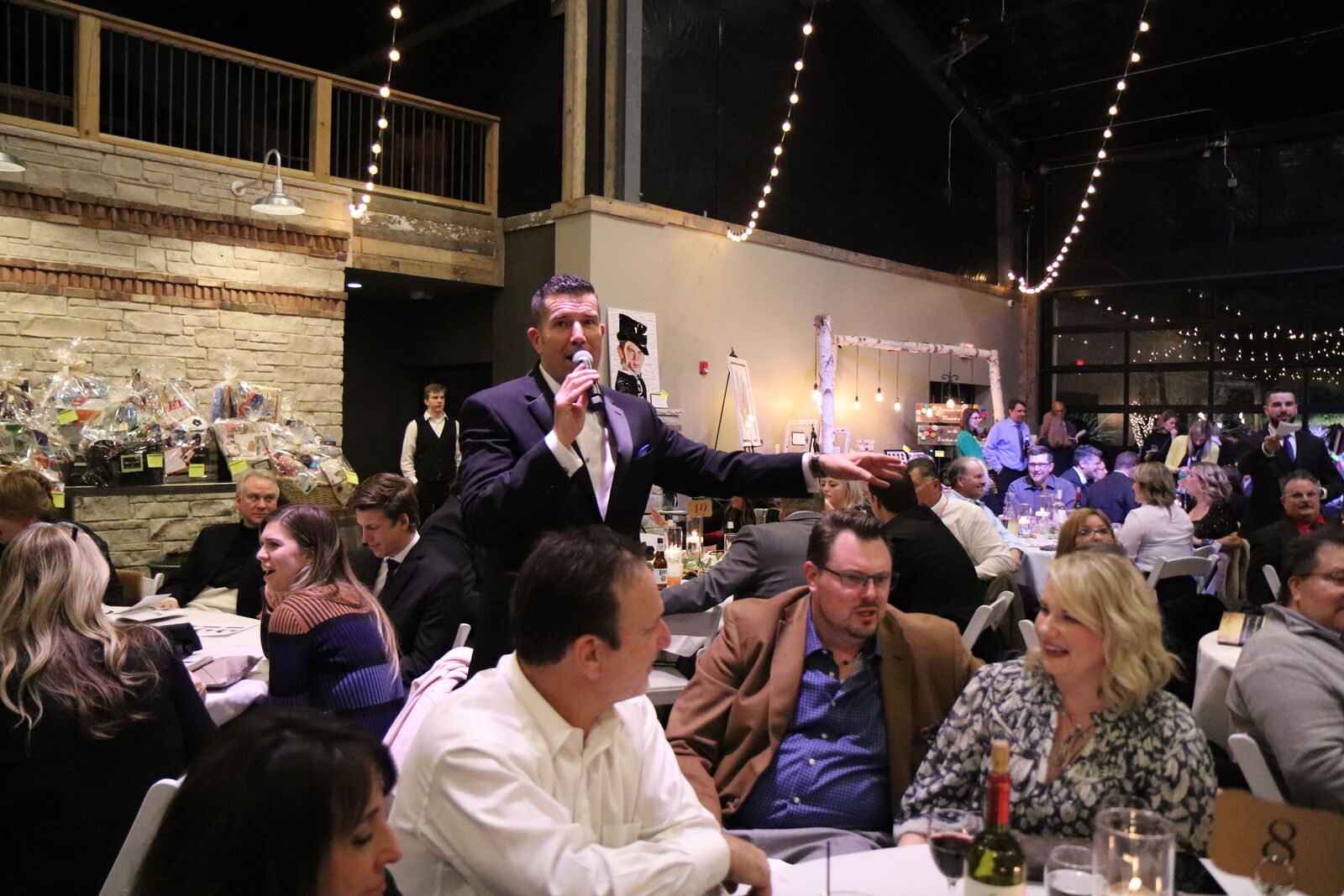 A full house under warm lights at a benefit evening.